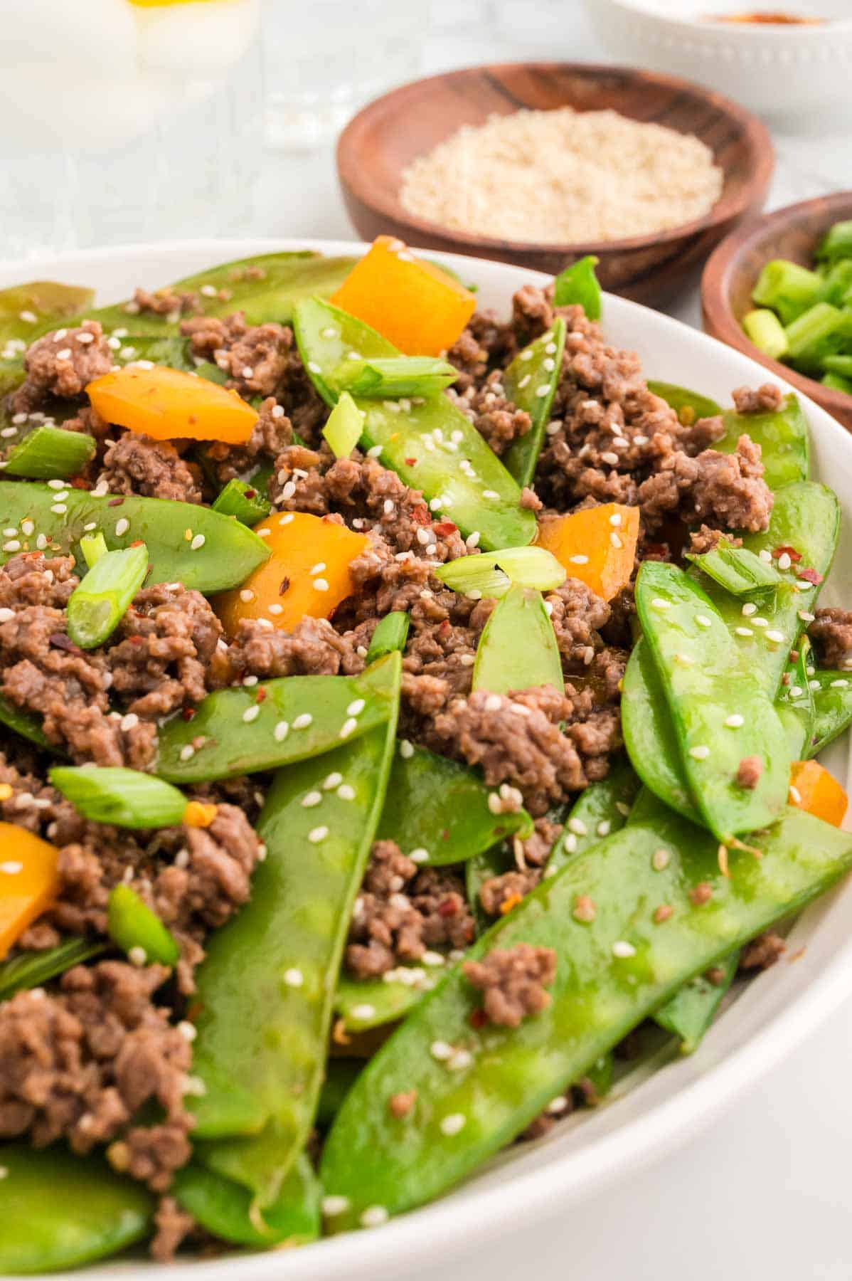 Ground Beef Stir Fry is an easy weeknight dinner recipe loaded with ground beef, snow peas, orange bell pepper, green onions and sesame seeds all cooked in a garlic, ginger, honey and soy sauce mixture.