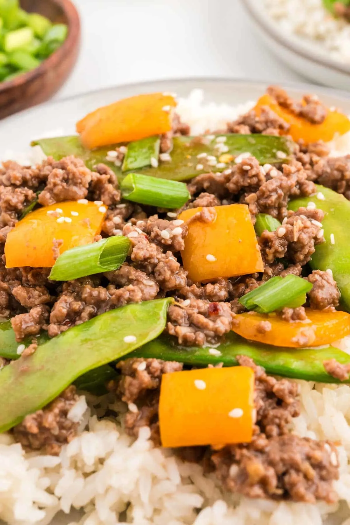 Ground Beef Stir Fry is an easy weeknight dinner recipe loaded with ground beef, snow peas, orange bell pepper, green onions and sesame seeds all cooked in a garlic, ginger, honey and soy sauce mixture.