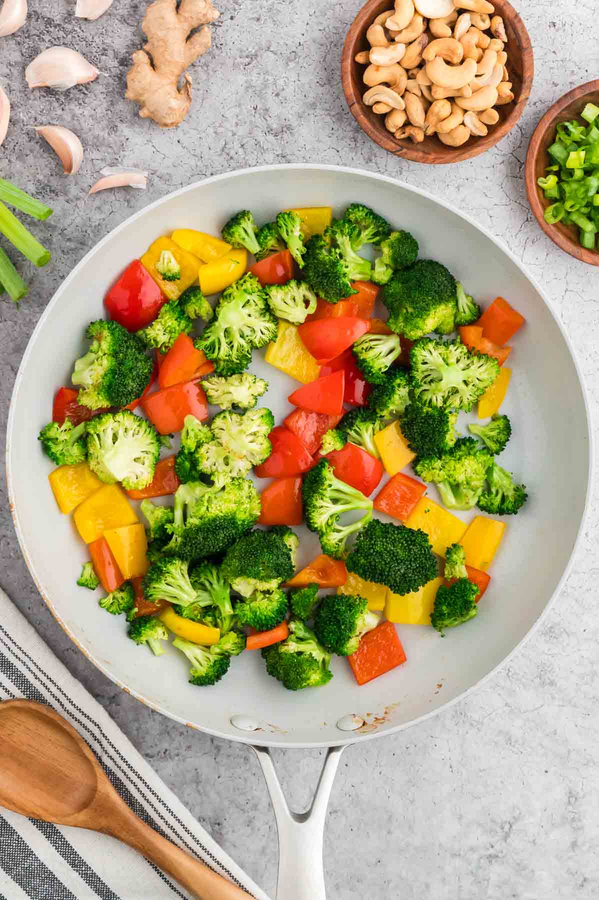 broccoli florets and chopped bell peppers cooking in a skillet