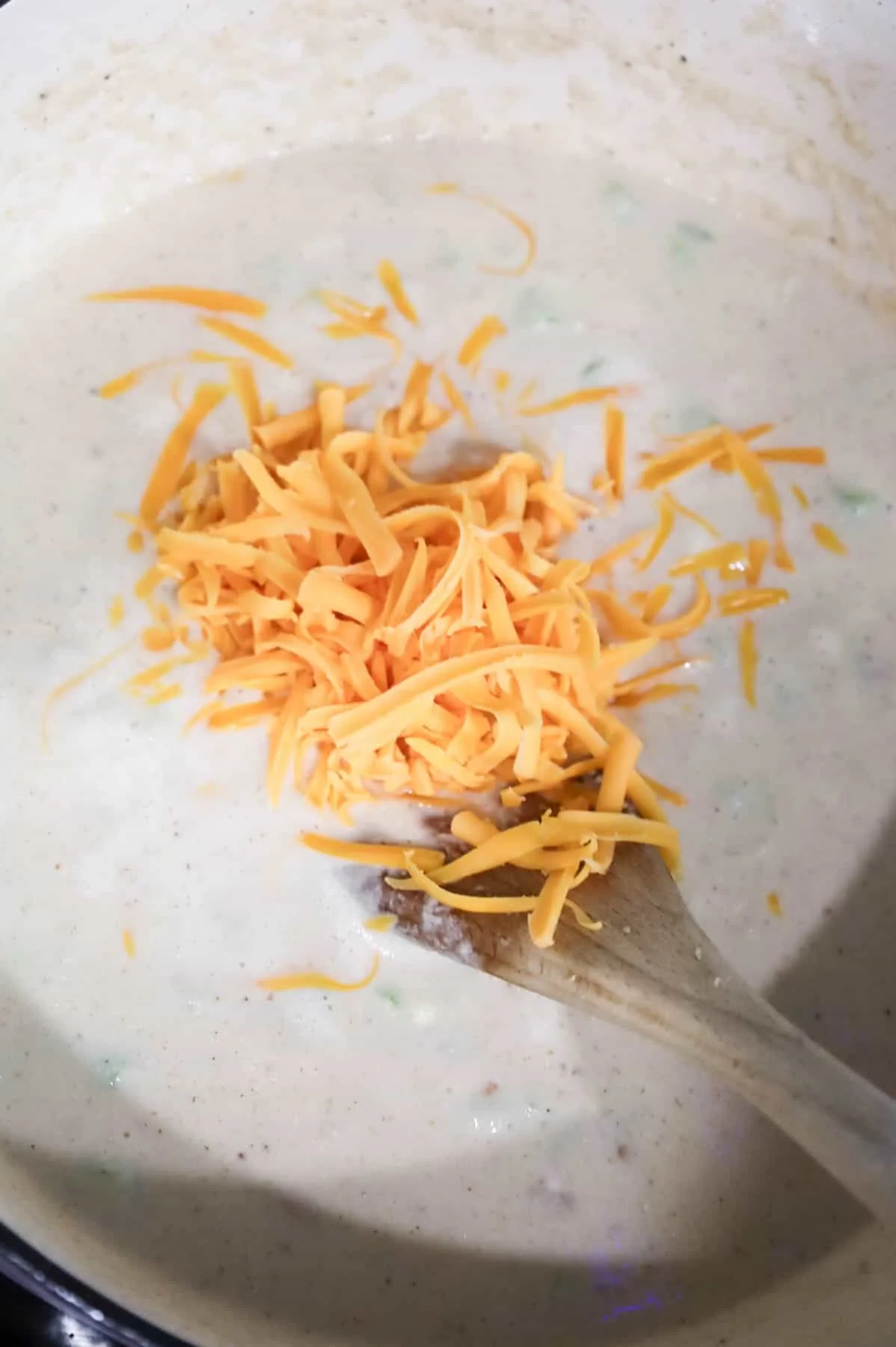 shredded cheddar cheese added to cauliflower soup