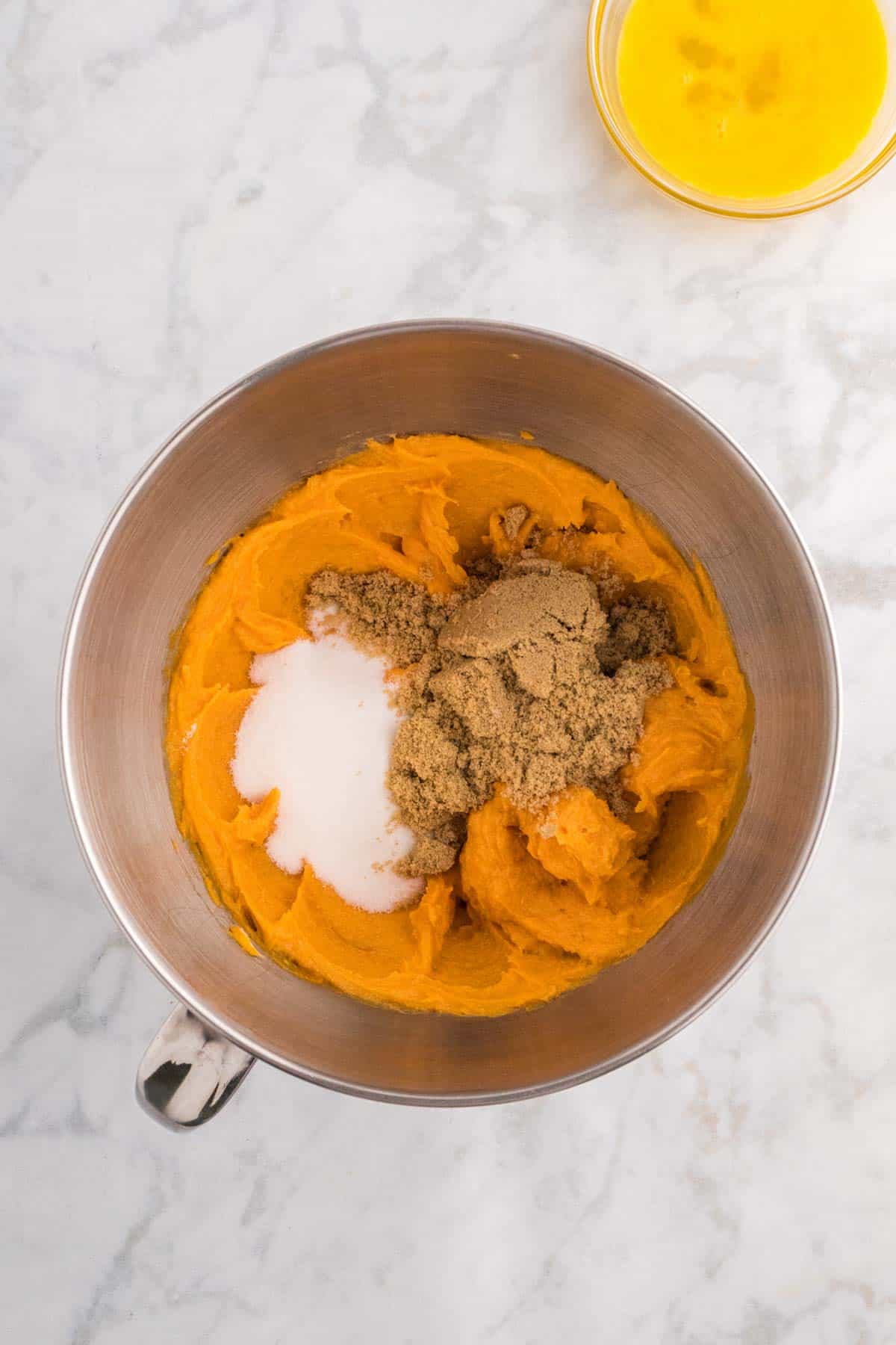 granulated sugar and brown sugar added to mixing bowl with sweet potato mixture