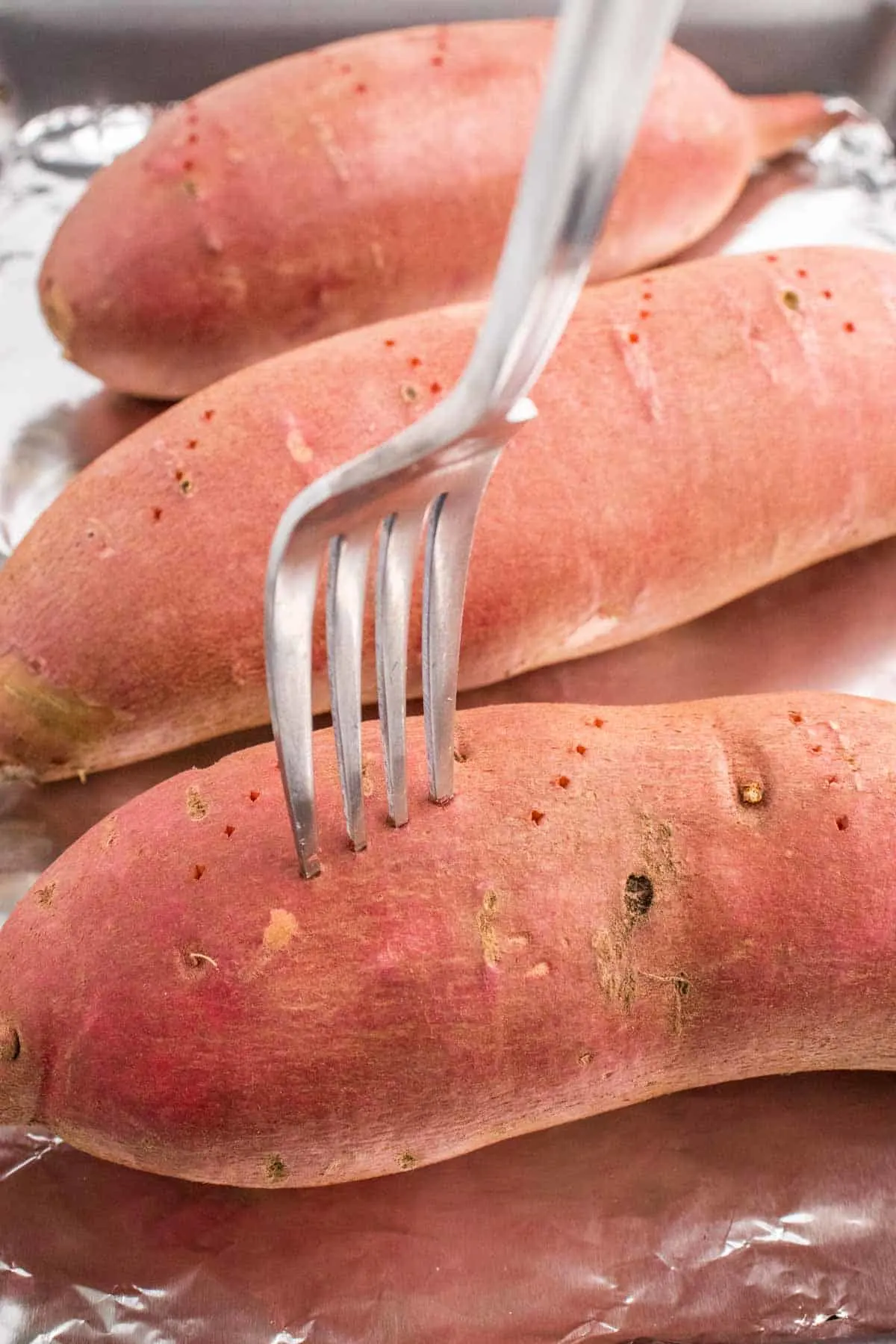 fork piercing holes in sweet potatoes