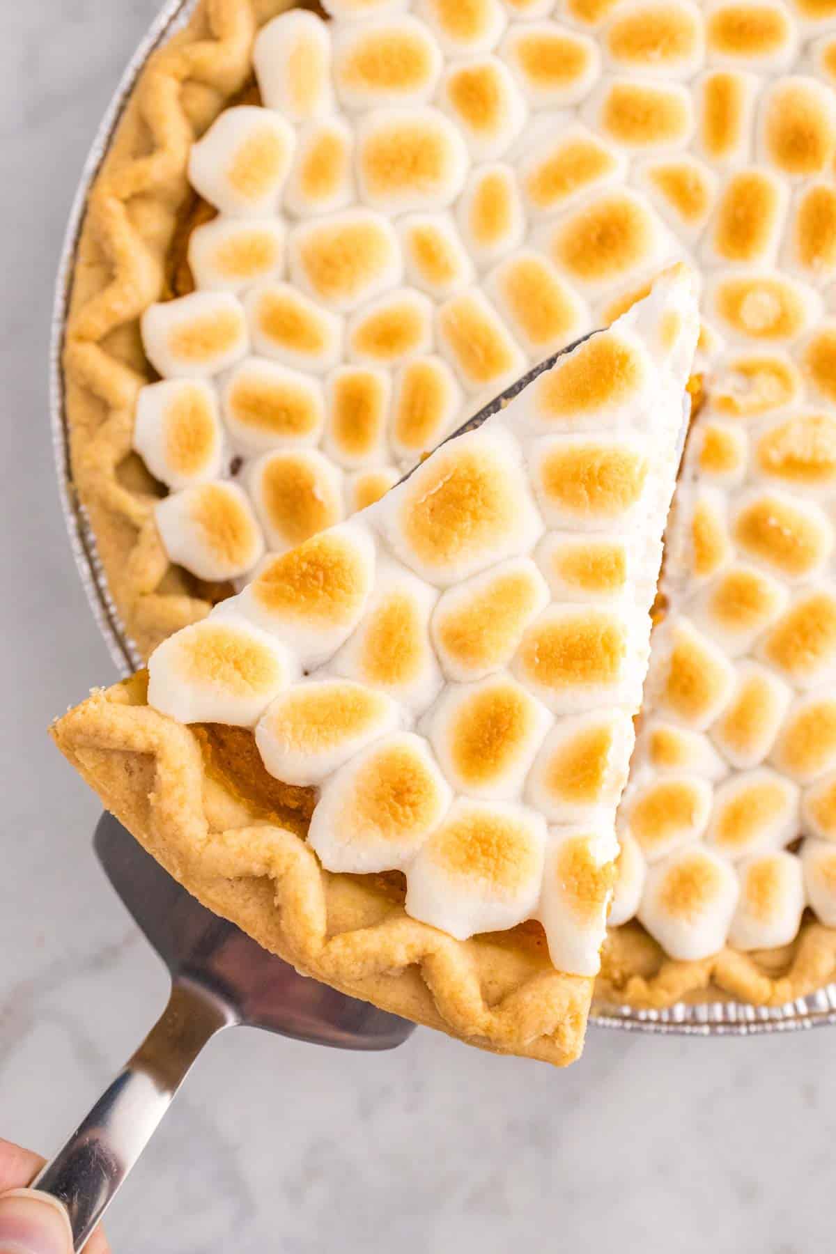 Sweet Potato Pie with Marshmallows is a classic Thanksgiving and Christmas dessert made with mashed sweet potatoes combined with butter, sugar, eggs, evaporated milk, cinnamon, nutmeg and ginger, baked in a flaky pie crust and topped with mini marshmallows.