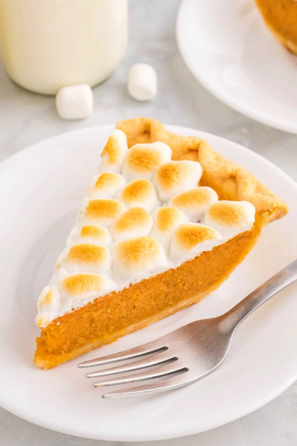Sweet Potato Pie with Marshmallows is a classic Thanksgiving and Christmas dessert made with mashed sweet potatoes combined with butter, sugar, eggs, evaporated milk, cinnamon, nutmeg and ginger, baked in a flaky pie crust and topped with mini marshmallows.