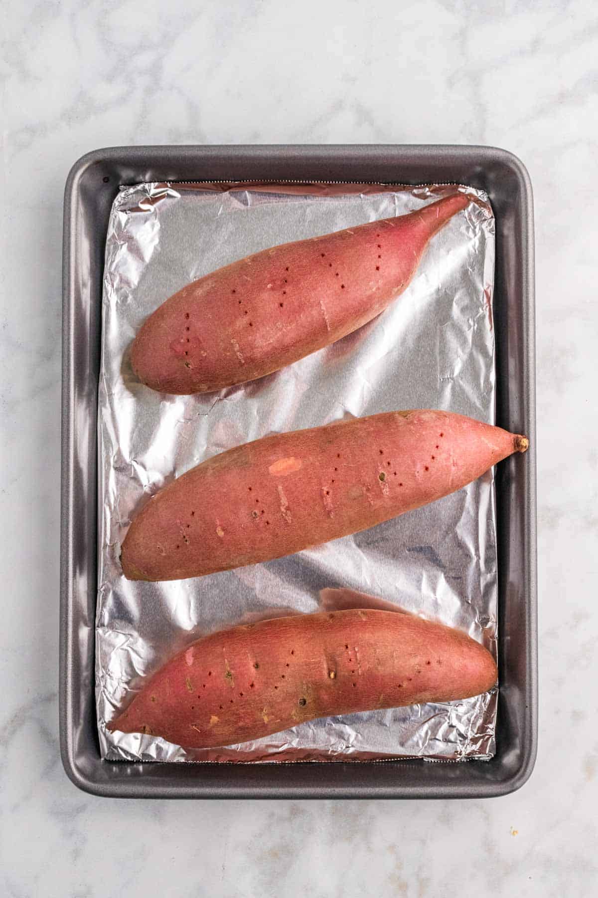 sweet potatoes on a foil lined baking sheet