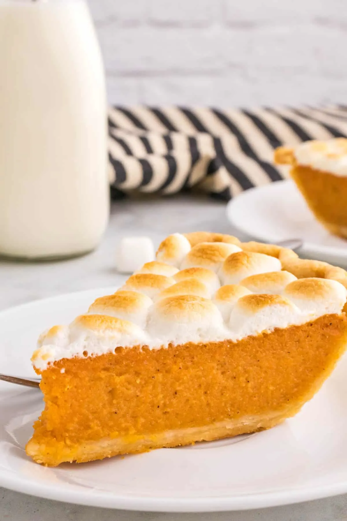Sweet Potato Pie with Marshmallows is a classic Thanksgiving and Christmas dessert made with mashed sweet potatoes combined with butter, sugar, eggs, evaporated milk, cinnamon, nutmeg and ginger, baked in a flaky pie crust and topped with mini marshmallows.