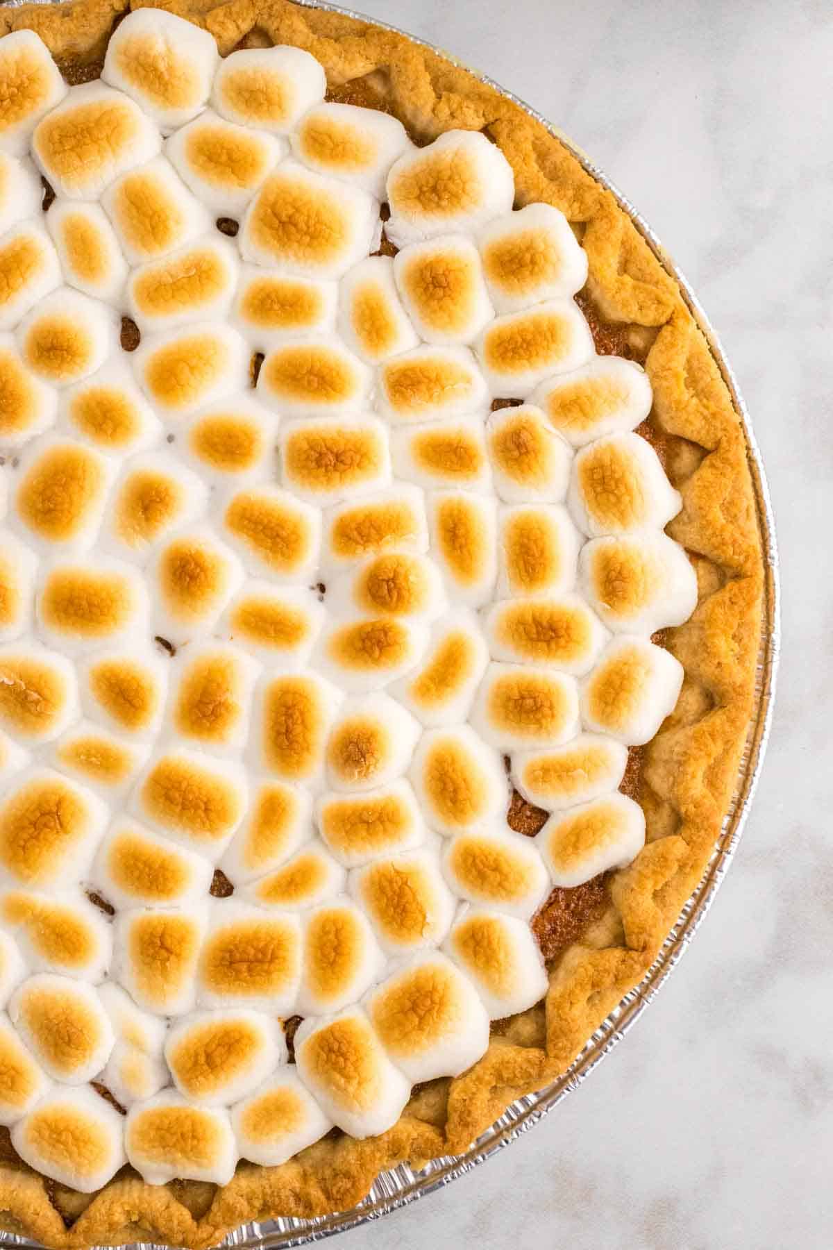 Sweet Potato Pie with Marshmallows is a classic Thanksgiving and Christmas dessert made with mashed sweet potatoes combined with butter, sugar, eggs, evaporated milk, cinnamon, nutmeg and ginger, baked in a flaky pie crust and topped with mini marshmallows.