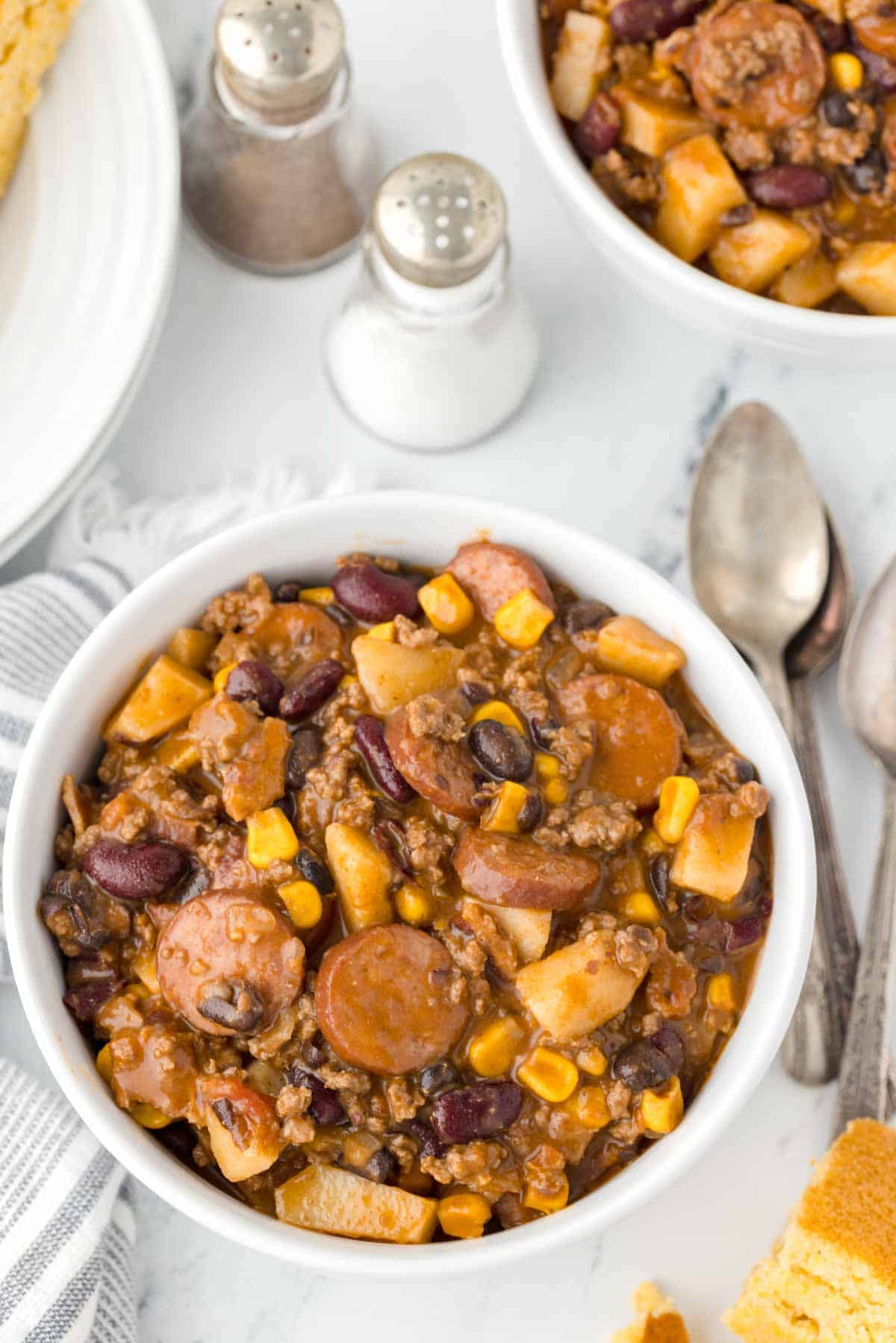 Texas Cowboy Stew is a hearty dish loaded with ground beef, smoked sausage, bacon, potatoes, corn, beans and diced tomatoes all in a flavourful beef broth.