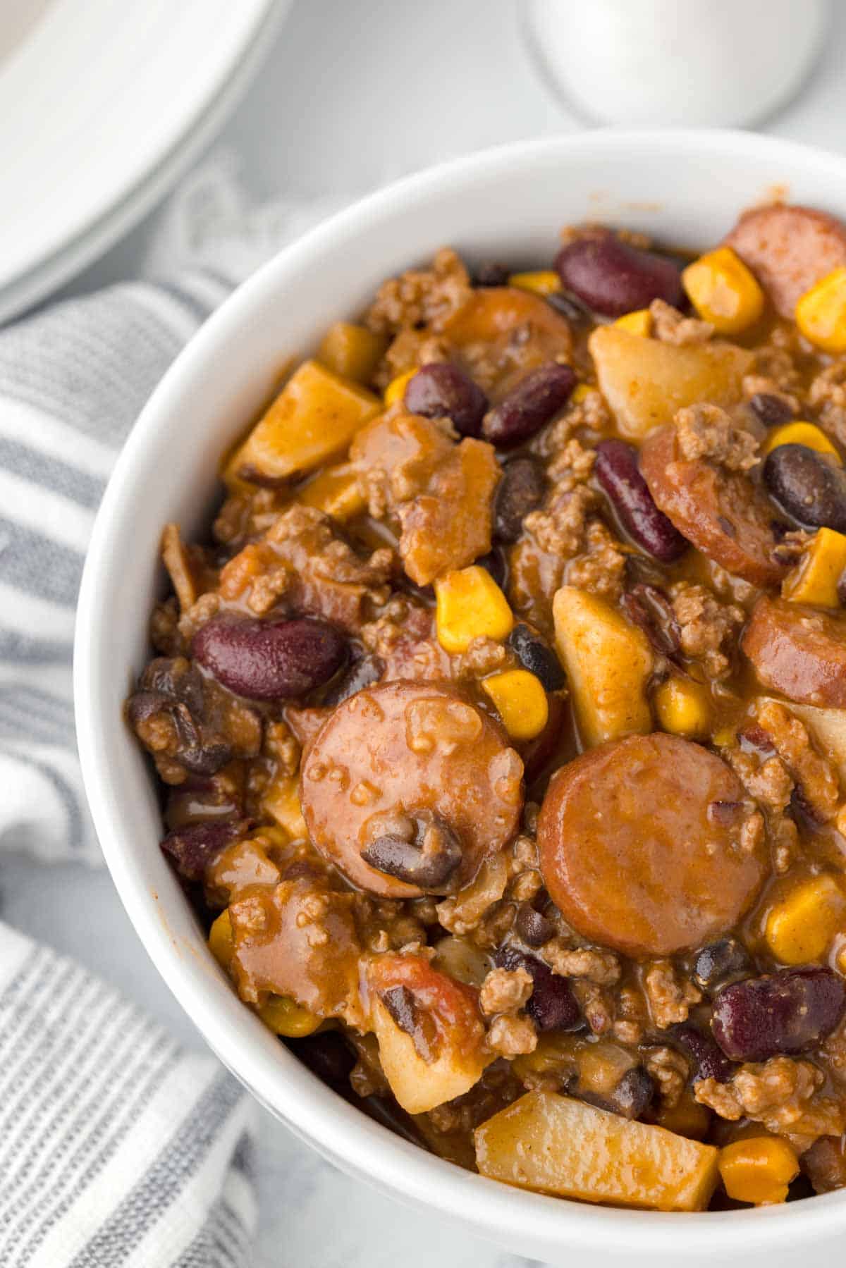 Texas Cowboy Stew is a hearty dish loaded with ground beef, smoked sausage, bacon, potatoes, corn, beans and diced tomatoes all in a flavourful beef broth.
