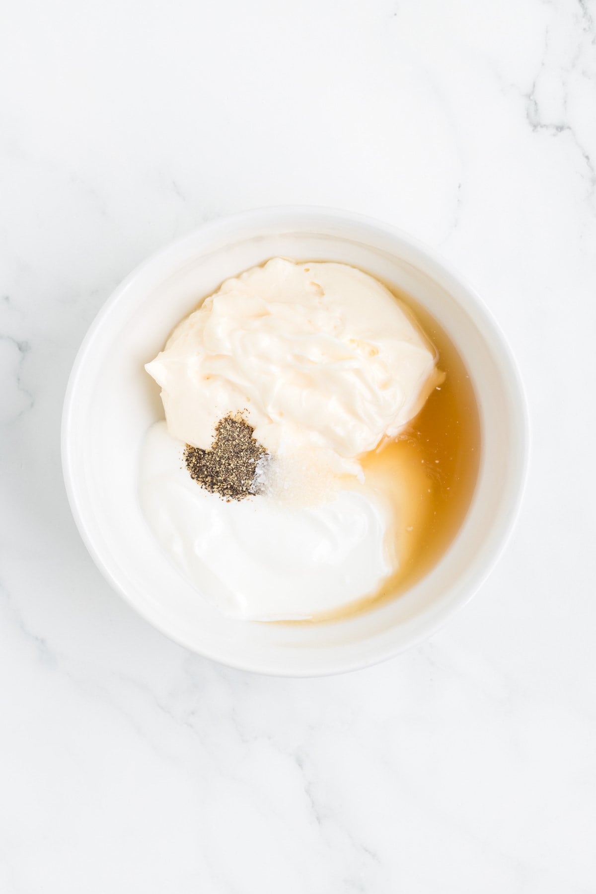 mayo, sour cream, apple cider vinegar, salt and pepper in a mixing bowl