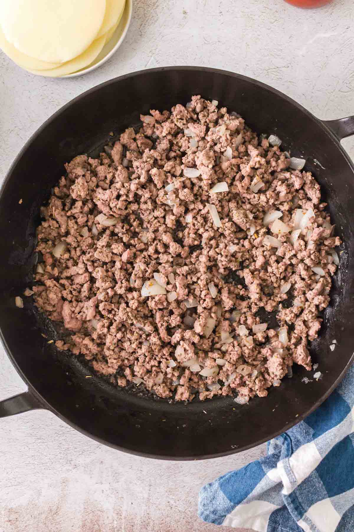 cooked ground beef and diced onions in a skillet