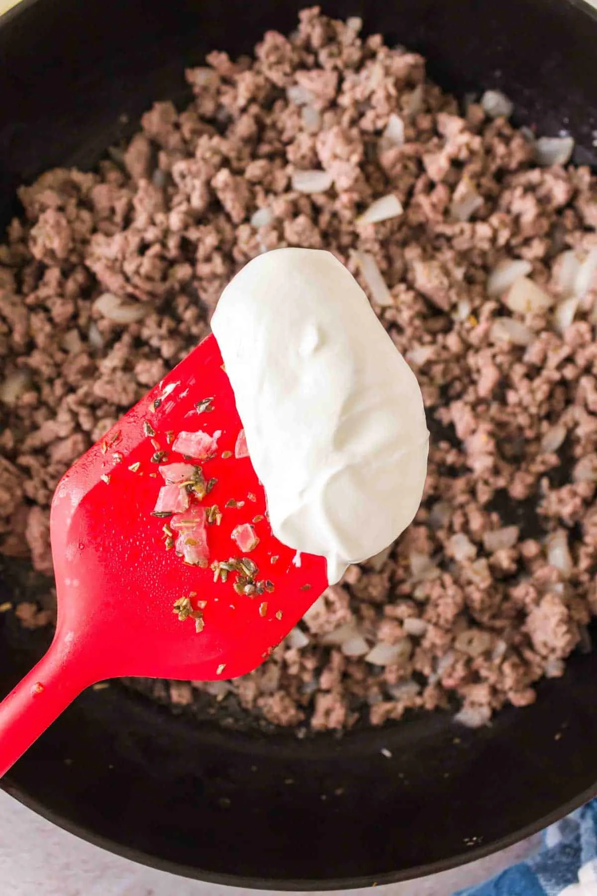 sour cream being added to skillet with ground beef