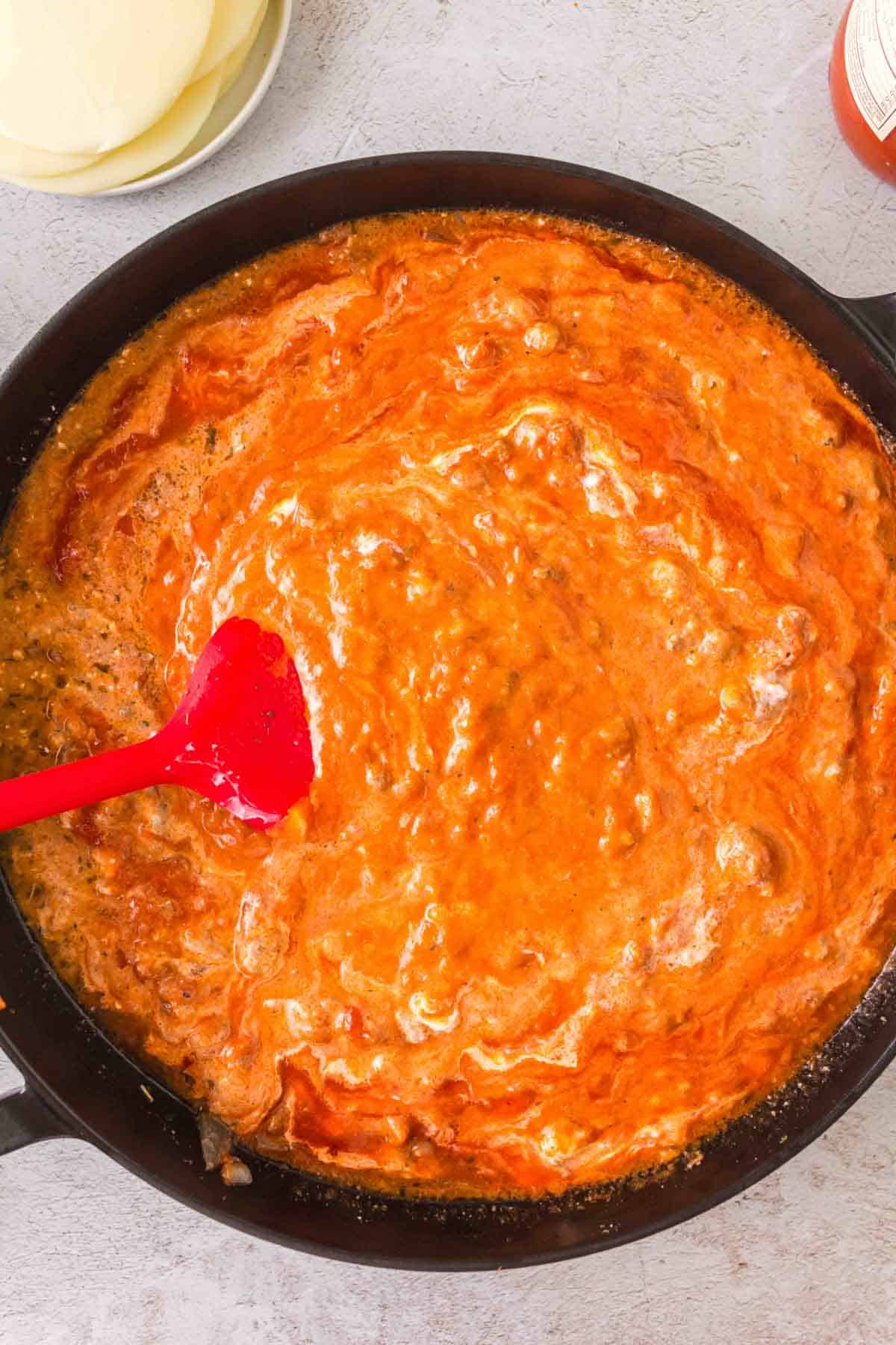 marinara, sour cream, heavy cream and ground beef mixture in a skillet