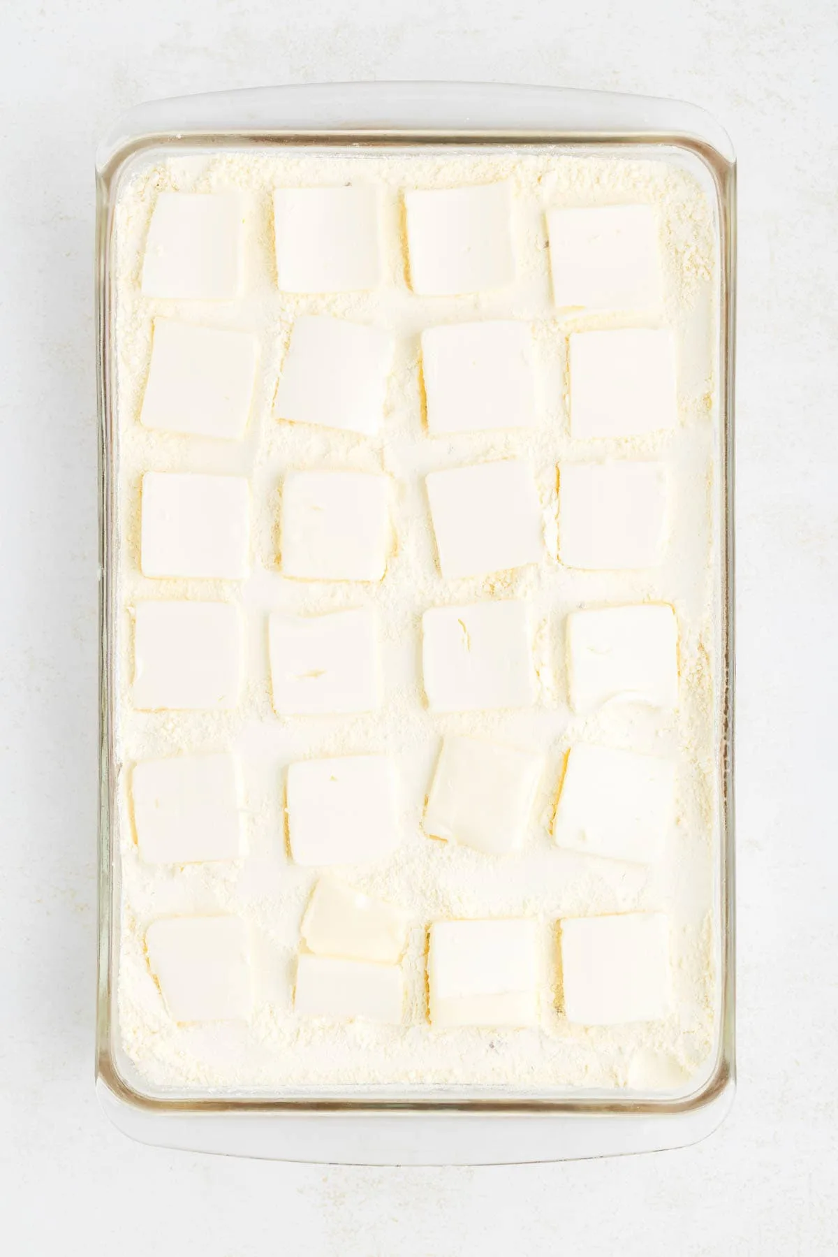 butter squares on top of dry cake mix in a baking dish