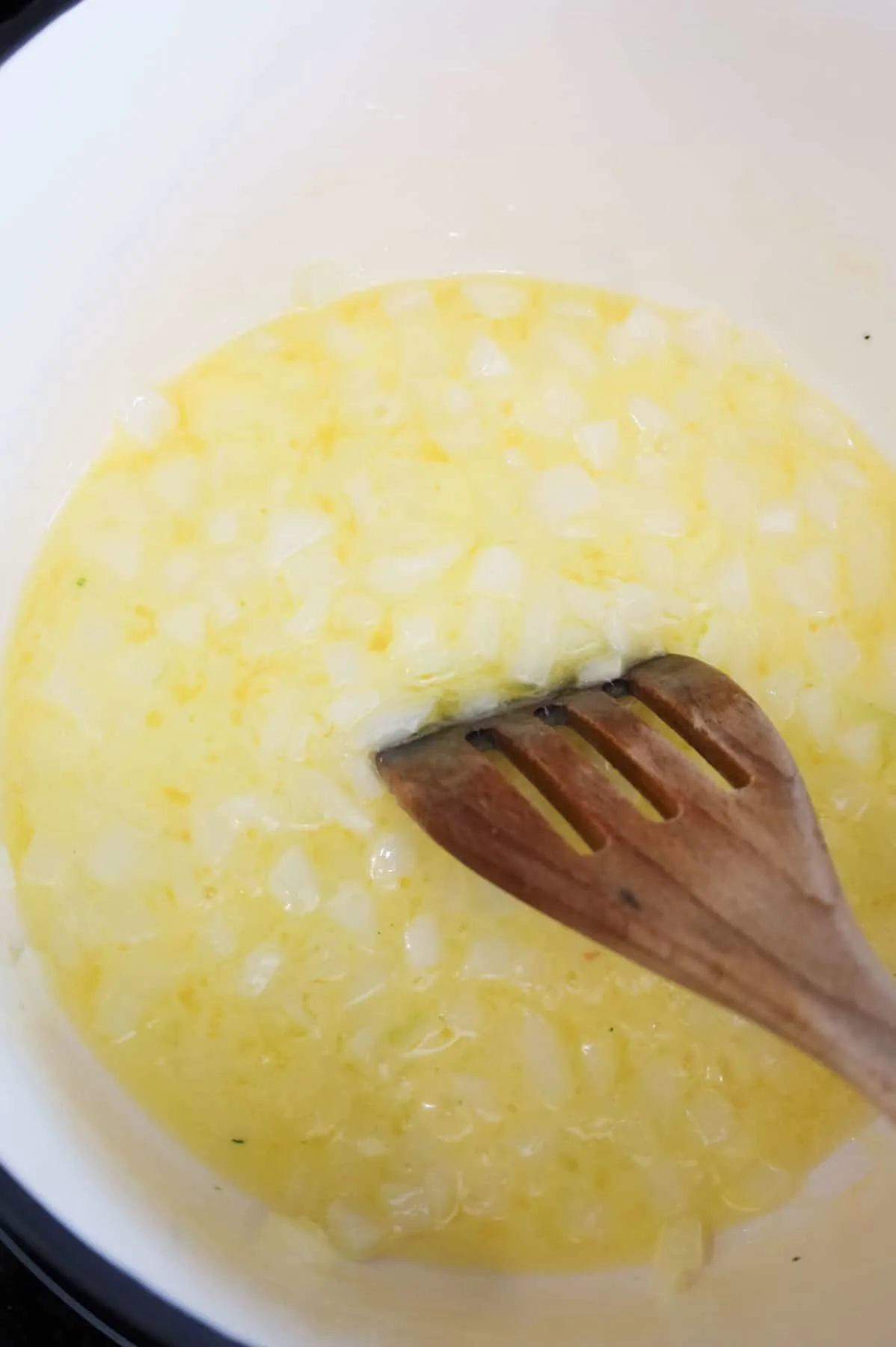 diced onions cooking in melted butter in a pot