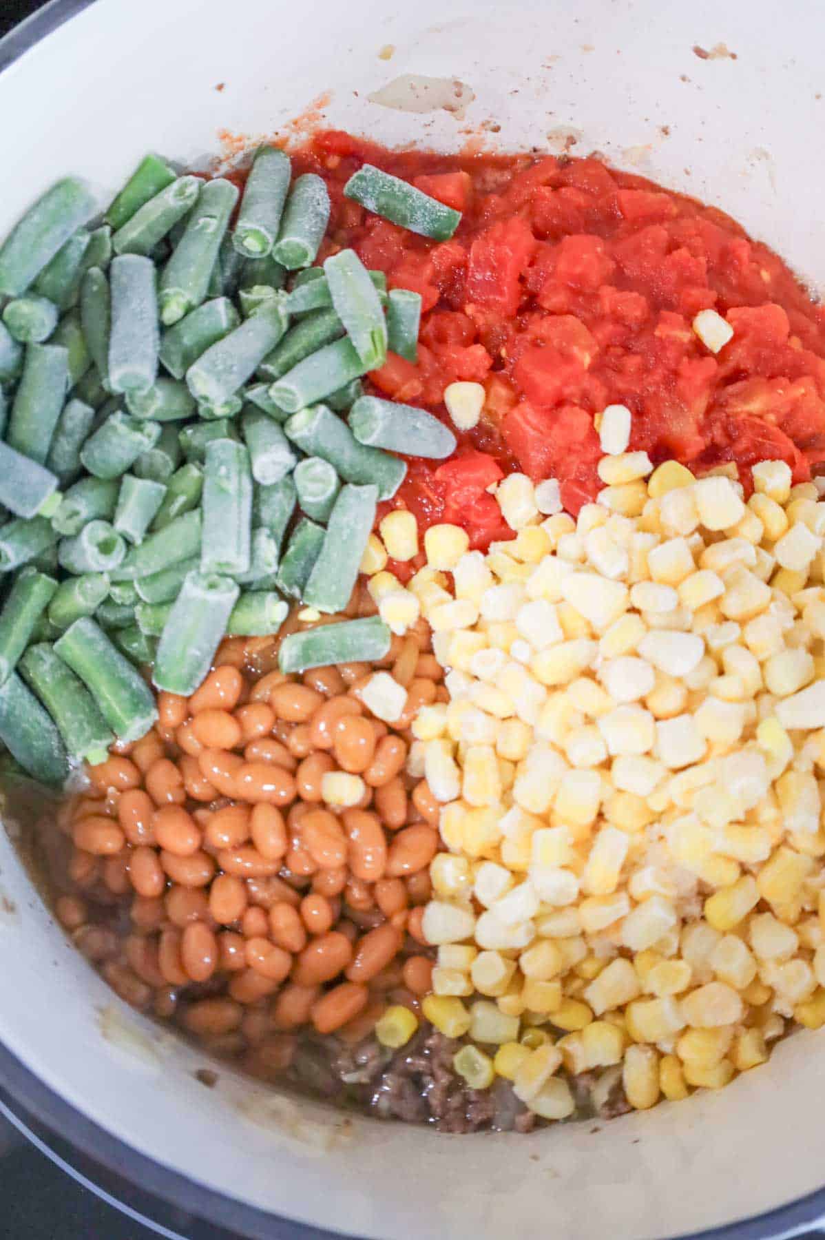 green beans, Rotel, baked beans and corn in a soup pot