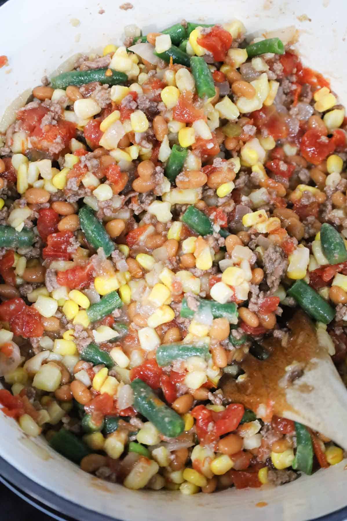 corn, green bean, rotel and ground beef mixture in a pot