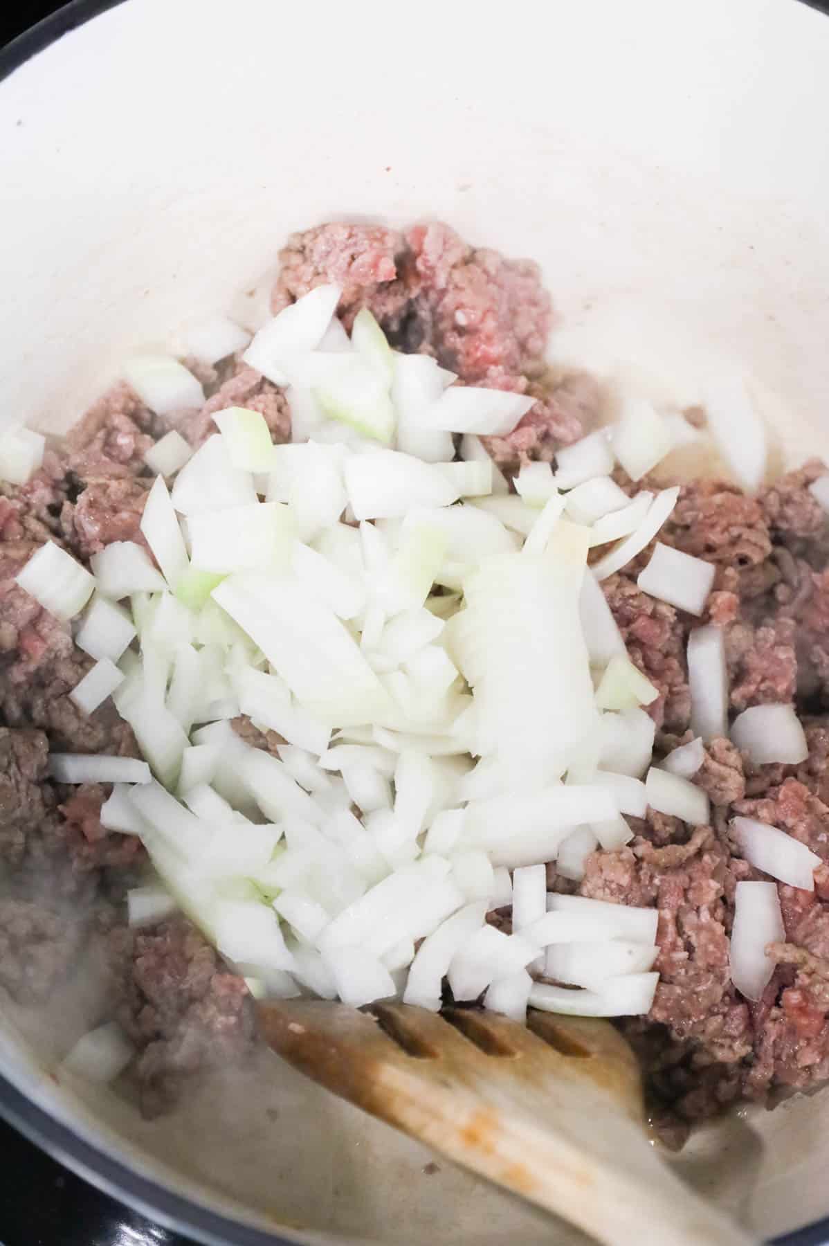 diced onions added to a pot with ground beef