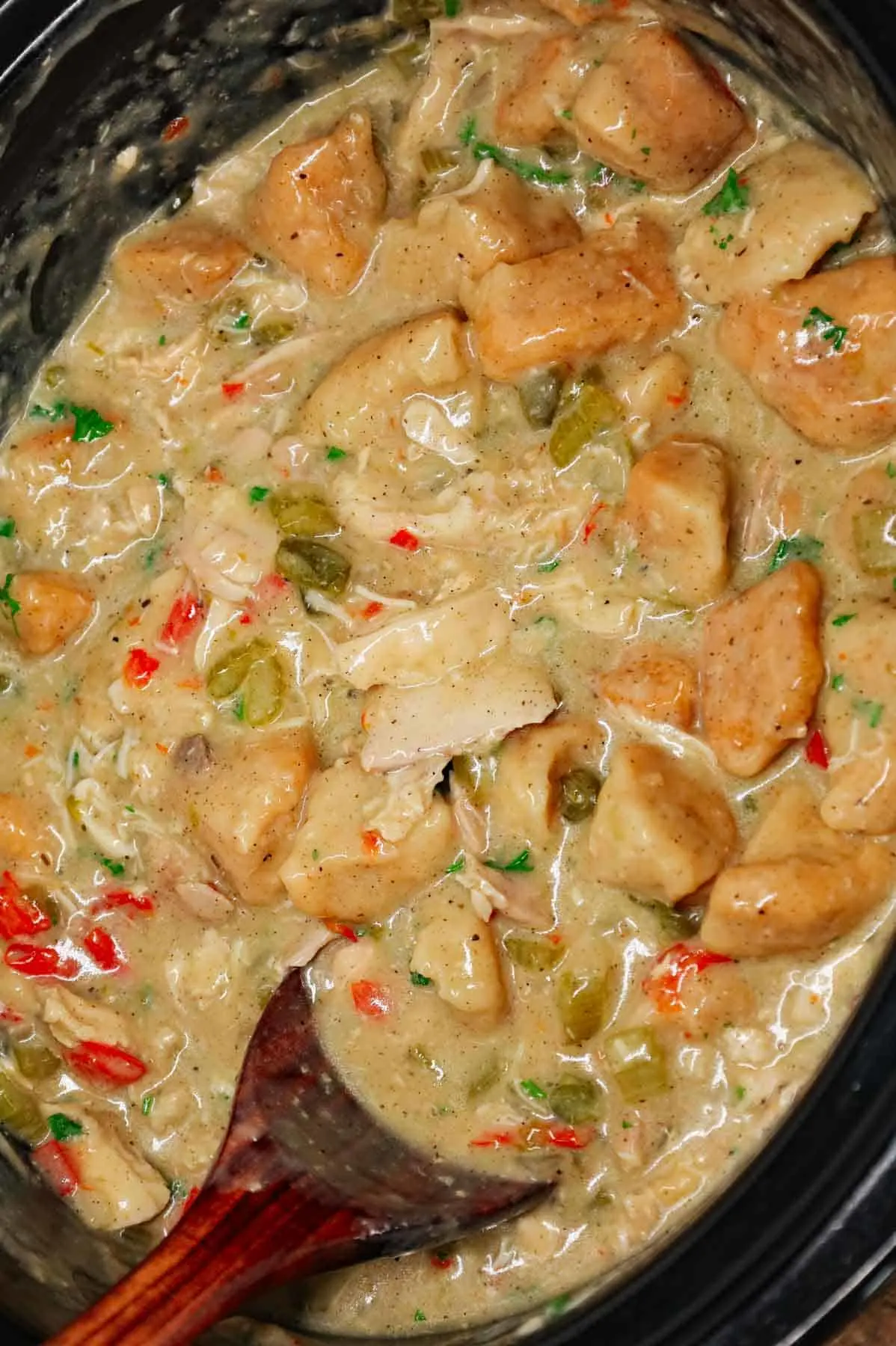 Crock Pot Chicken and Biscuits is a delicious comfort food dish made with boneless skinless chicken thighs, diced onions, celery, red and green bell peppers, cream of mushroom soup, cream of chicken soup, poultry seasoning and Pillsbury refrigerated biscuits.