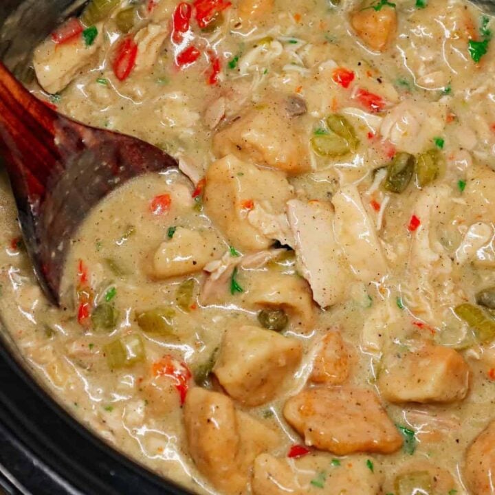 Crock Pot Chicken and Biscuits is a delicious comfort food dish made with boneless skinless chicken thighs, diced onions, celery, red and green bell peppers, cream of mushroom soup, cream of chicken soup, poultry seasoning and Pillsbury refrigerated biscuits.