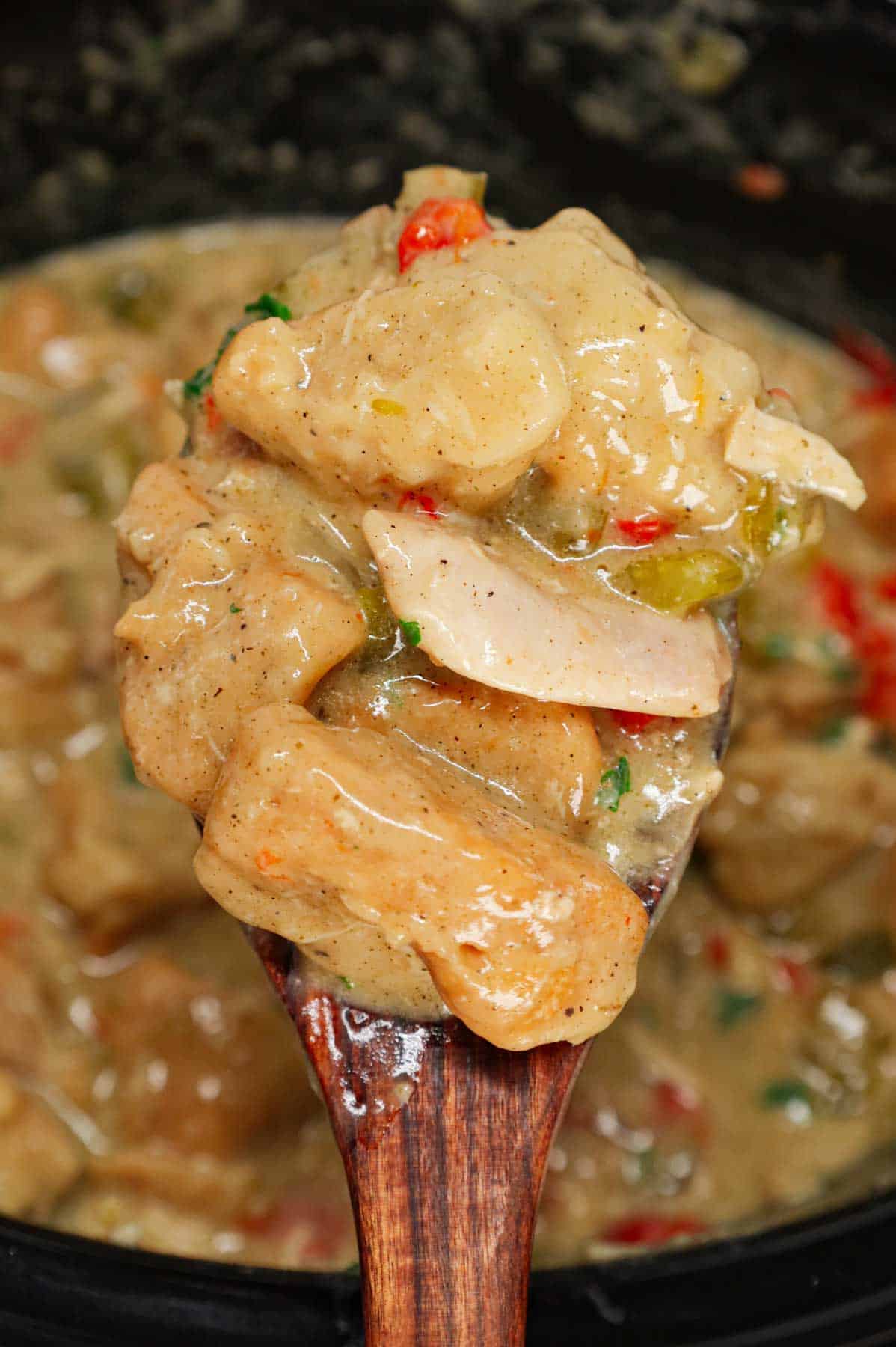 Crock Pot Chicken and Biscuits is a delicious comfort food dish made with boneless skinless chicken thighs, diced onions, celery, red and green bell peppers, cream of mushroom soup, cream of chicken soup, poultry seasoning and Pillsbury refrigerated biscuits.