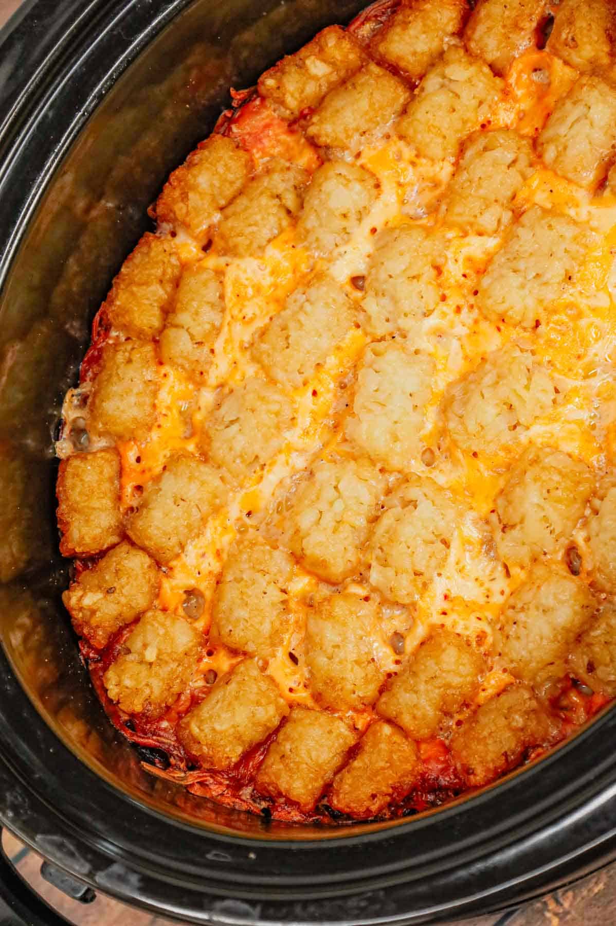 Crock Pot Tater Tot Casserole is a hearty slow cooker dish loaded with ground beef, tater tots, corn, diced tomatoes, cream of mushroom soup and shredded cheddar cheese.