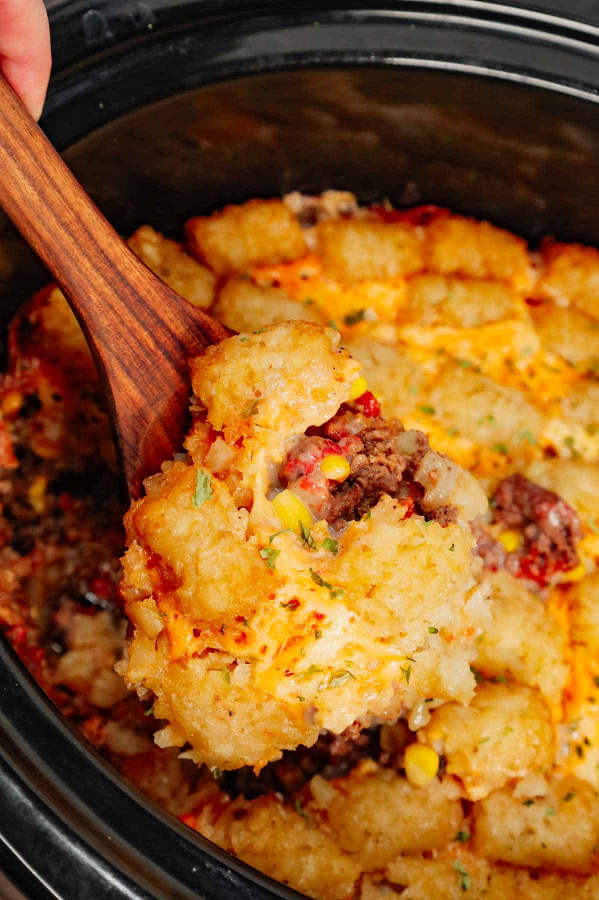 Crock Pot Tater Tot Casserole is a hearty slow cooker dish loaded with ground beef, tater tots, corn, diced tomatoes, cream of mushroom soup and shredded cheddar cheese.