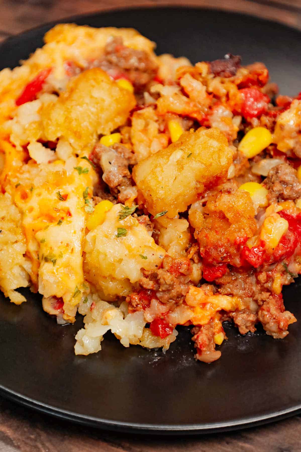 Crock Pot Tater Tot Casserole is a hearty slow cooker dish loaded with ground beef, tater tots, corn, diced tomatoes, cream of mushroom soup and shredded cheddar cheese.