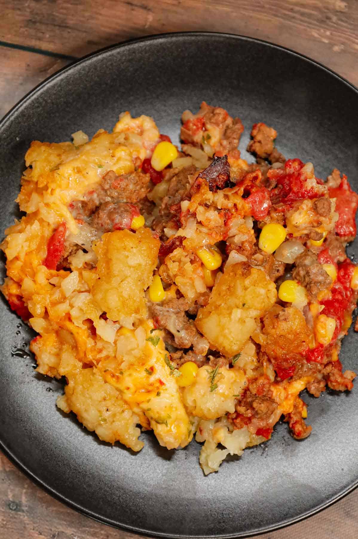 Crock Pot Tater Tot Casserole is a hearty slow cooker dish loaded with ground beef, tater tots, corn, diced tomatoes, cream of mushroom soup and shredded cheddar cheese.