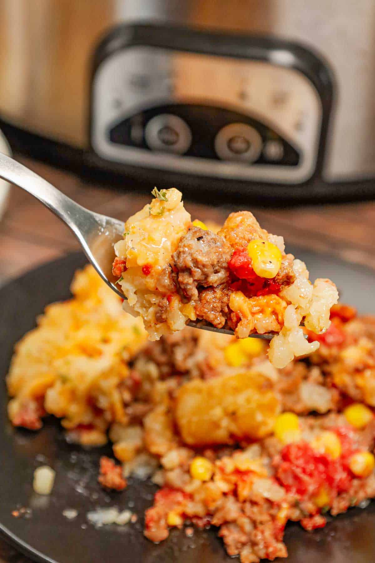 Crock Pot Tater Tot Casserole is a hearty slow cooker dish loaded with ground beef, tater tots, corn, diced tomatoes, cream of mushroom soup and shredded cheddar cheese.