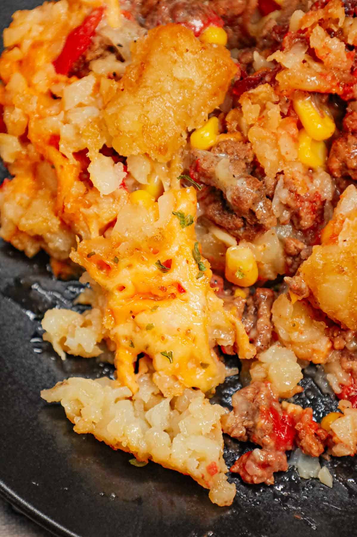 Crock Pot Tater Tot Casserole is a hearty slow cooker dish loaded with ground beef, tater tots, corn, diced tomatoes, cream of mushroom soup and shredded cheddar cheese.