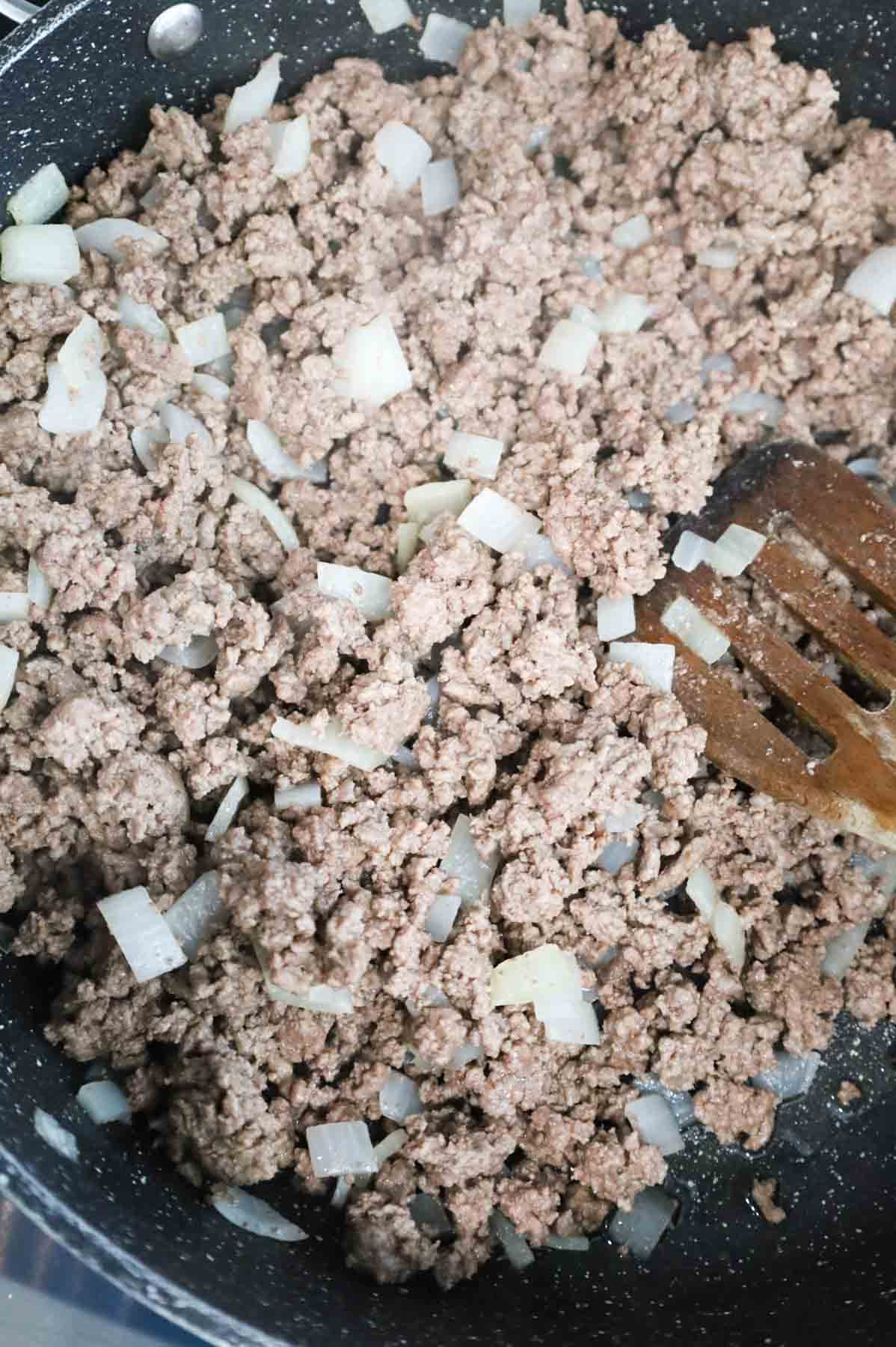 cooked ground beef and diced onions in a skillet