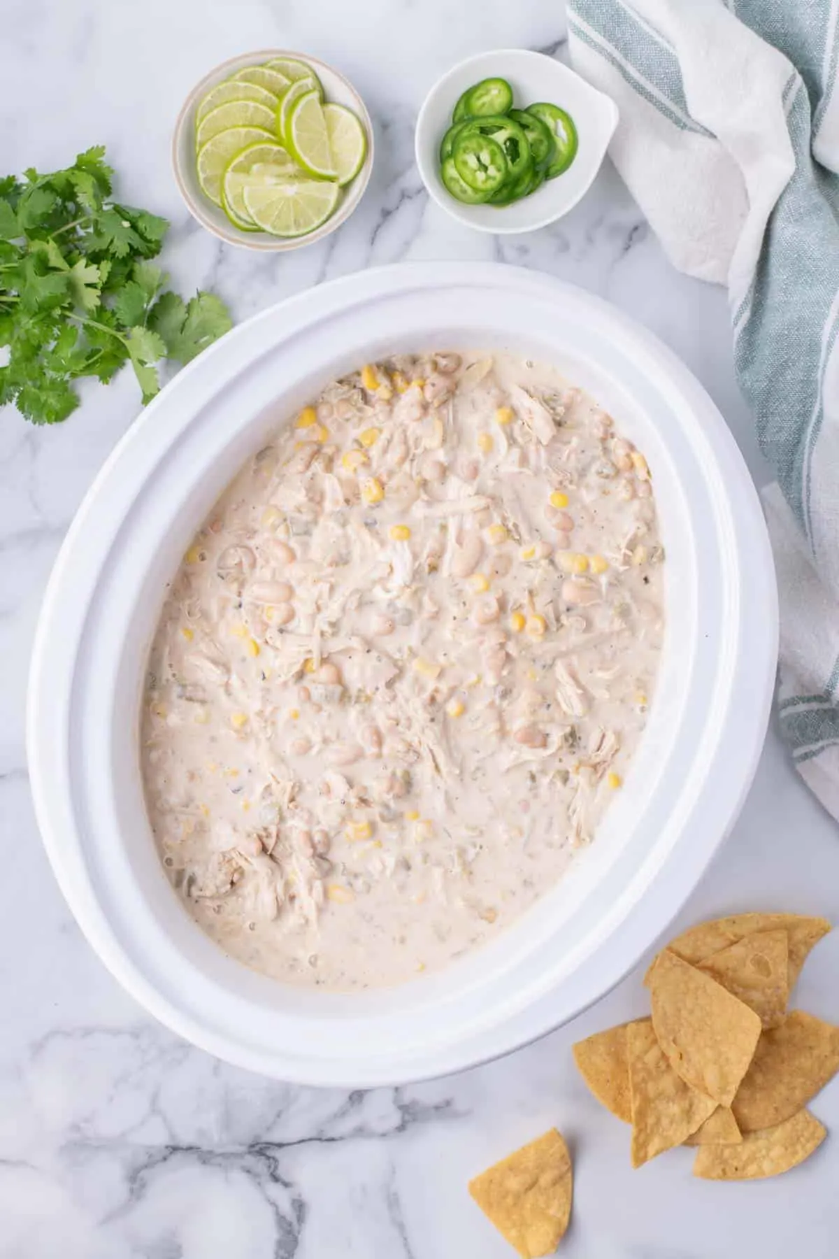 Crock Pot White Chicken Chili is a hearty slow cooker dinner recipe loaded with navy beans, chicken thighs, green chiles, corn, onions and spices.