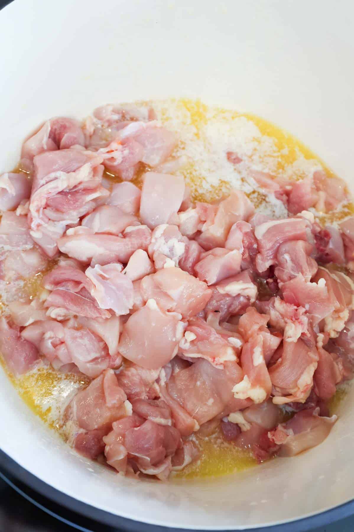 raw chicken thigh pieces add to a Dutch oven with melted butter