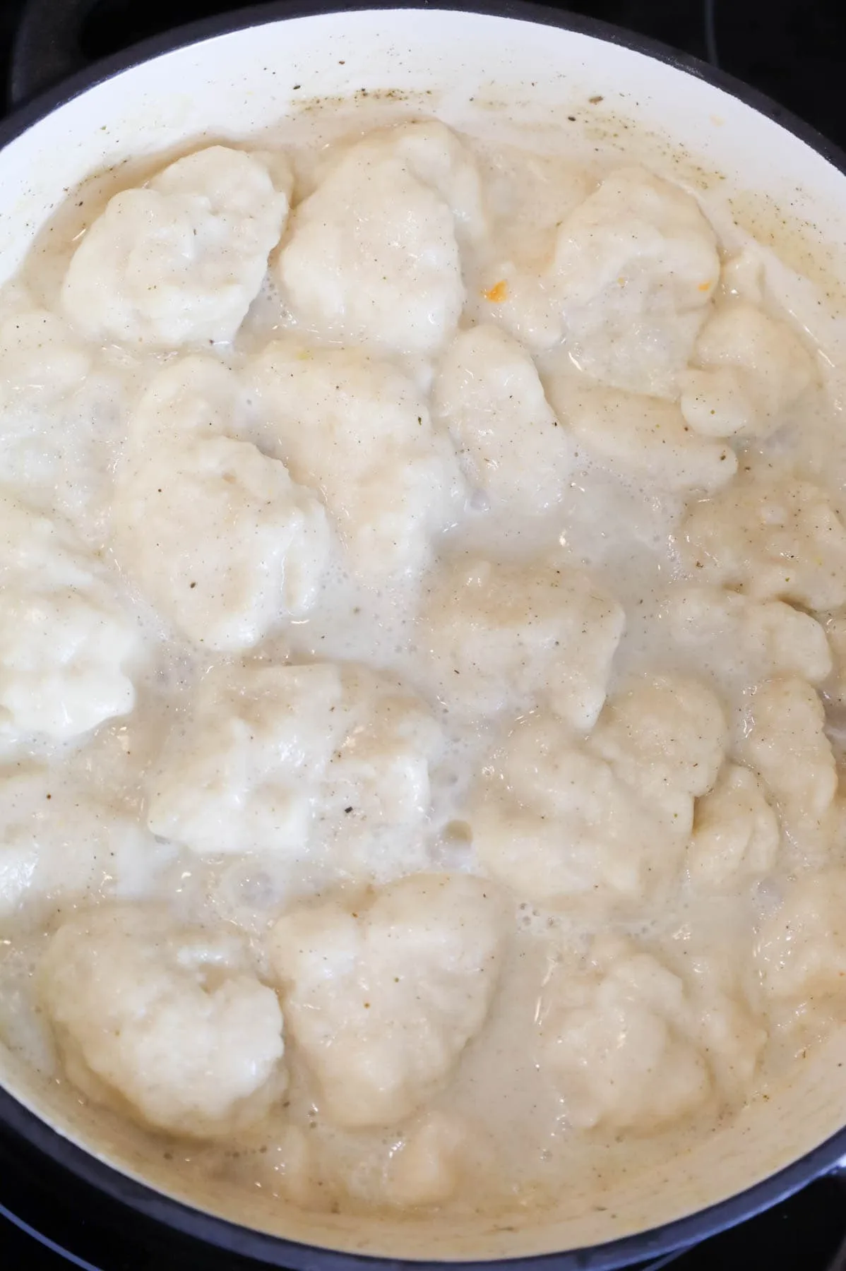 Bisquick dumplings cooking in creamy broth