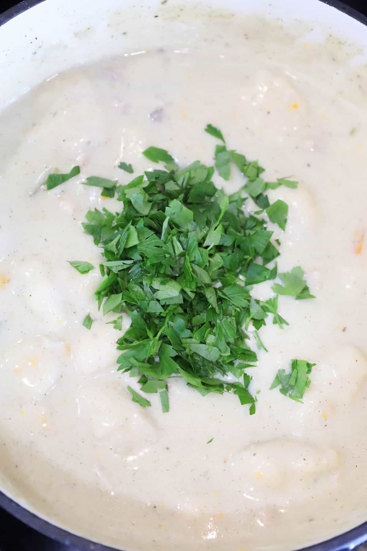 chopped parsley added to pot with chicken and dumplings