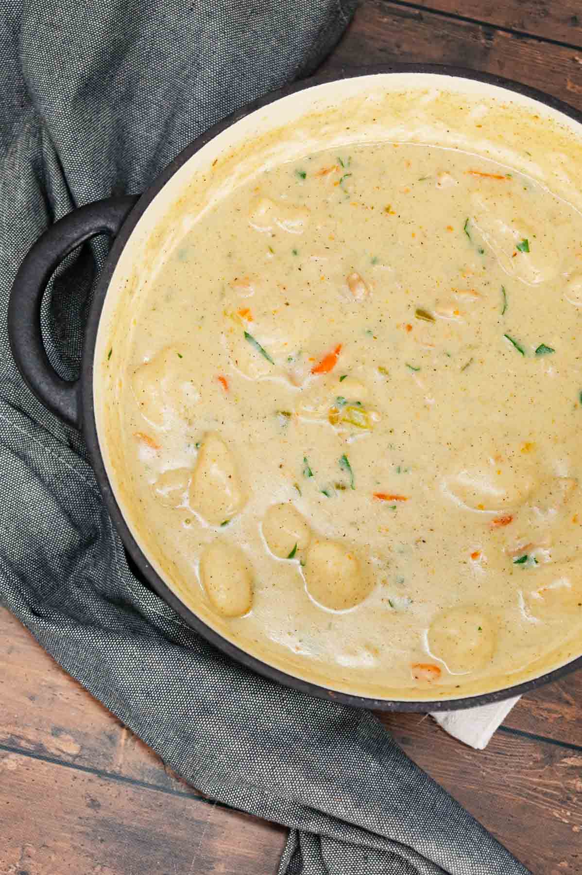 Dutch Oven Chicken and Dumplings is hearty dinner recipe loaded with chunks of chicken, onion, celery, carrots and soft doughy Bisquick dumplings all in a creamy and flavourful broth.