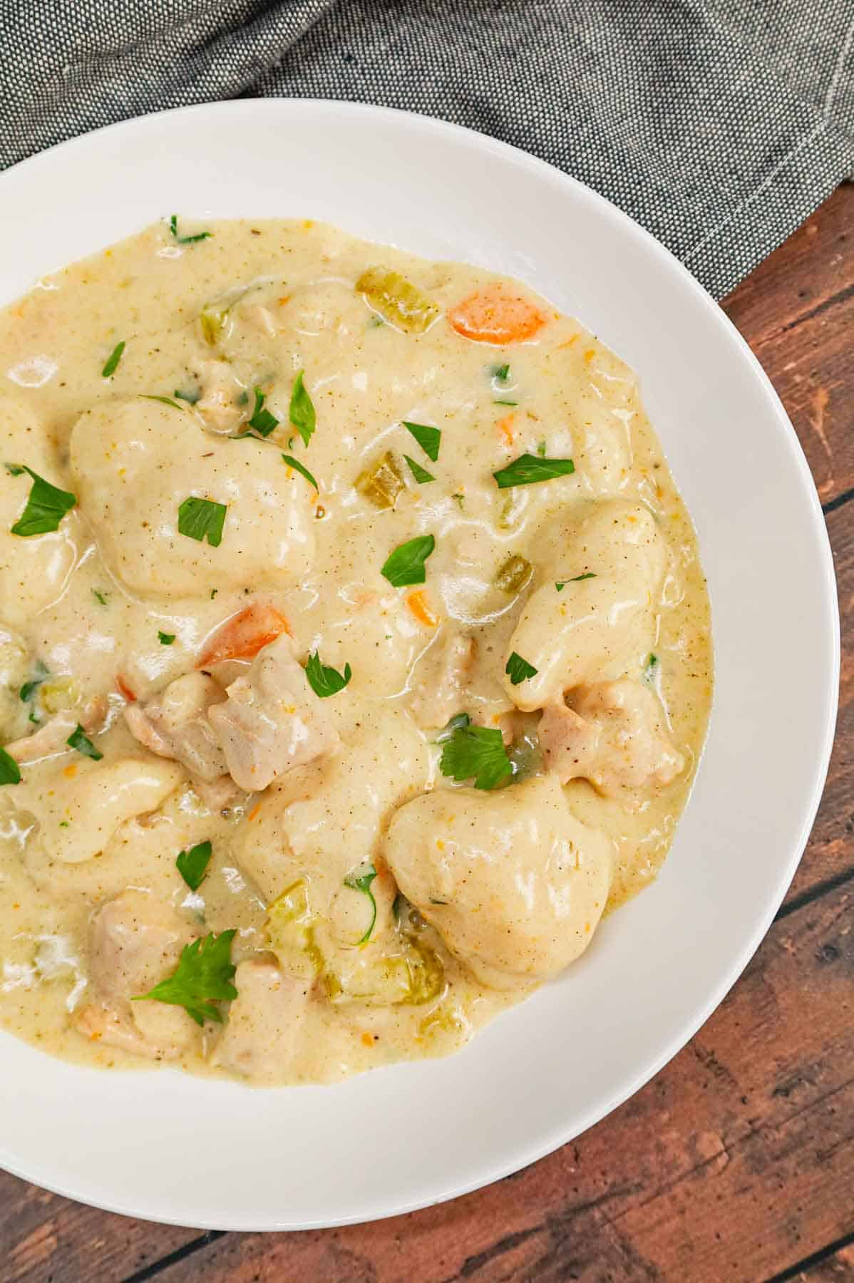 Dutch Oven Chicken and Dumplings is hearty dinner recipe loaded with chunks of chicken, onion, celery, carrots and soft doughy Bisquick dumplings all in a creamy and flavourful broth.