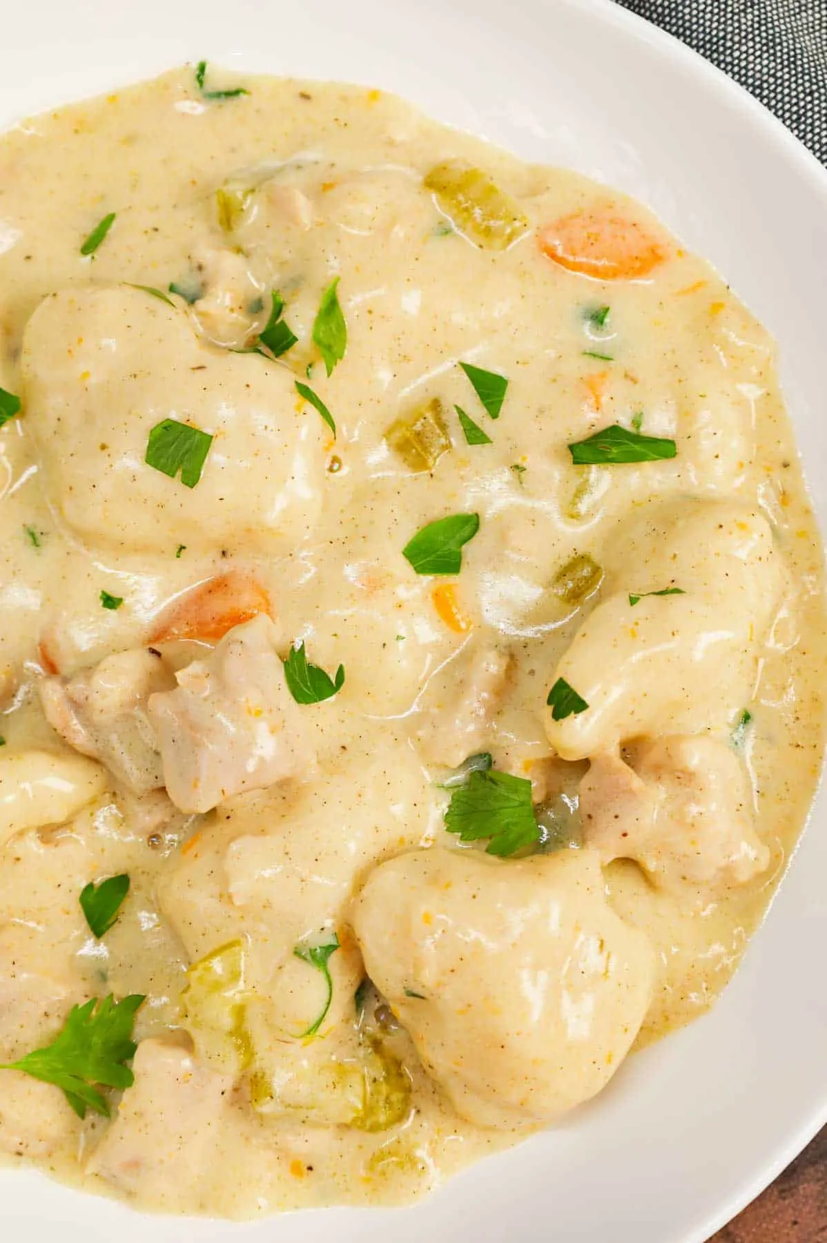 Dutch Oven Chicken and Dumplings is hearty dinner recipe loaded with chunks of chicken, onion, celery, carrots and soft doughy Bisquick dumplings all in a creamy and flavourful broth.