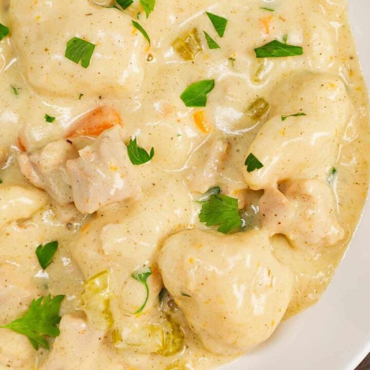 Dutch Oven Chicken and Dumplings is hearty dinner recipe loaded with chunks of chicken, onion, celery, carrots and soft doughy Bisquick dumplings all in a creamy and flavourful broth.