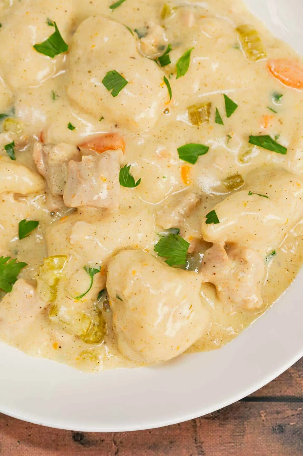 Dutch Oven Chicken and Dumplings is hearty dinner recipe loaded with chunks of chicken, onion, celery, carrots and soft doughy Bisquick dumplings all in a creamy and flavourful broth.
