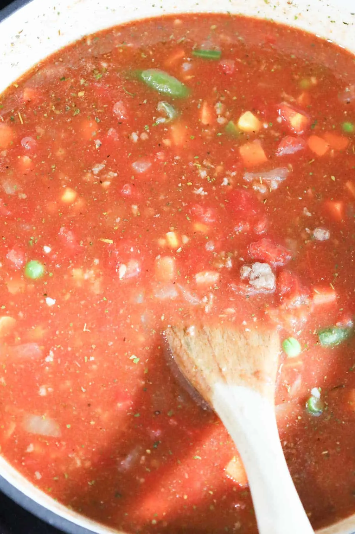 stirring Italian seasoning into hamburger soup