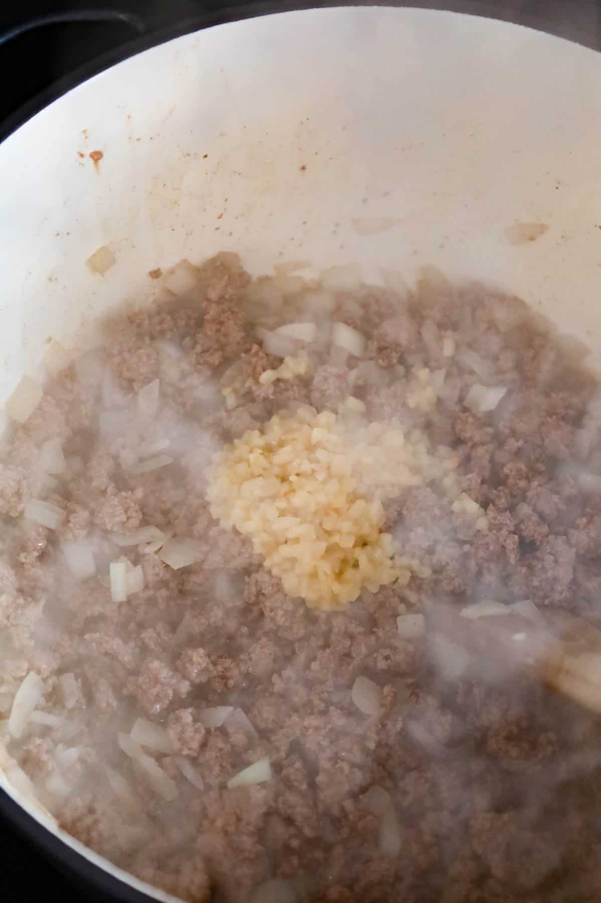 minced garlic added to pot with cooked ground beef and diced onions