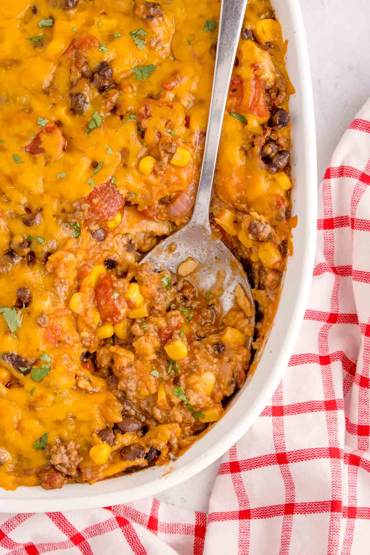 Mexican Ground Beef Casserole is a hearty dish loaded with ground beef, diced tomatoes, black beans, corn, cheddar cheese and corn tortillas.