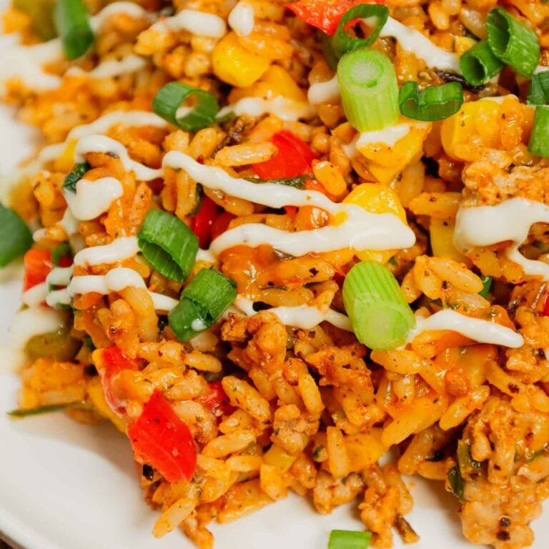 Cajun Ground Chicken and Rice is an easy weeknight dinner recipe loaded with long grain and wild rice, ground chicken, diced bell peppers, corn, chopped spinach, Cajun seasoning, green onions, ranch dressing and cheddar cheese.