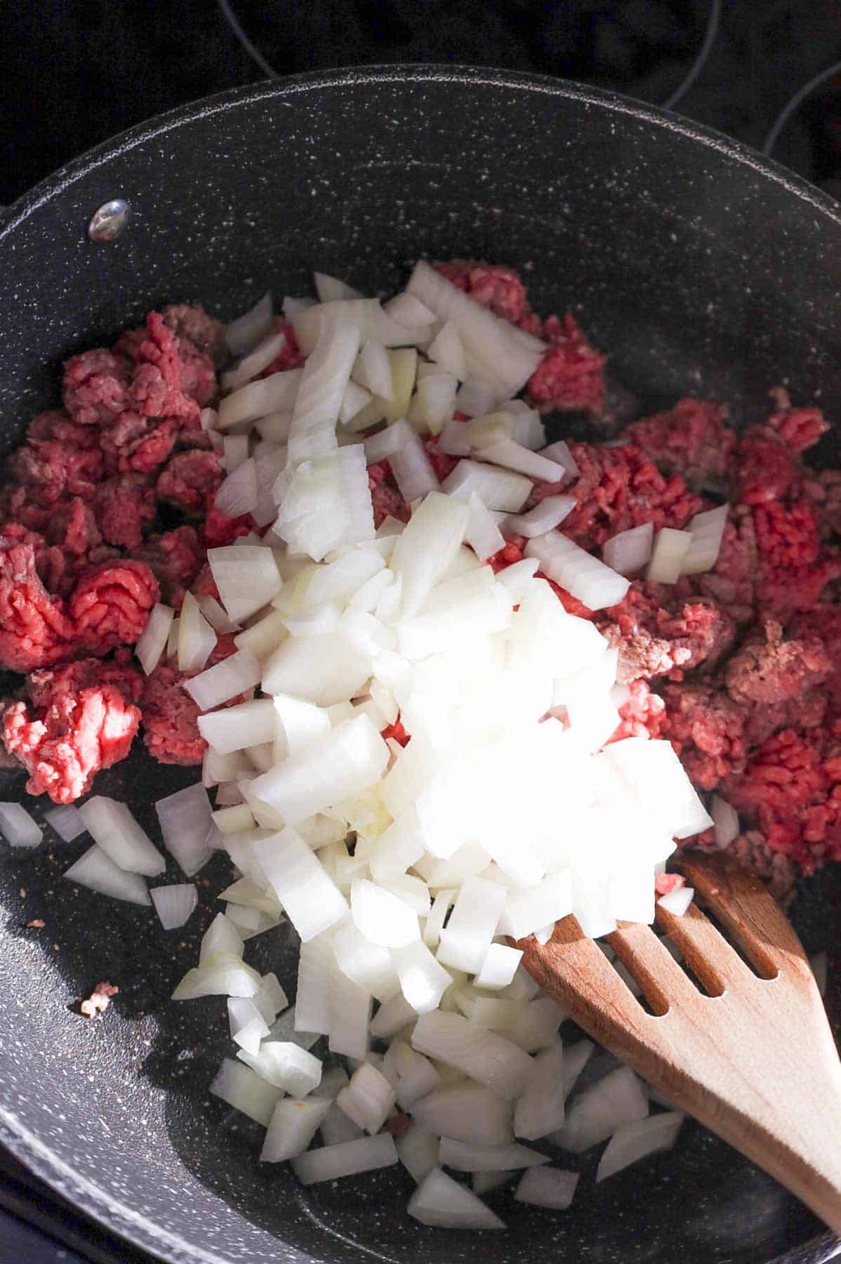 diced onions added to skillet with ground beef