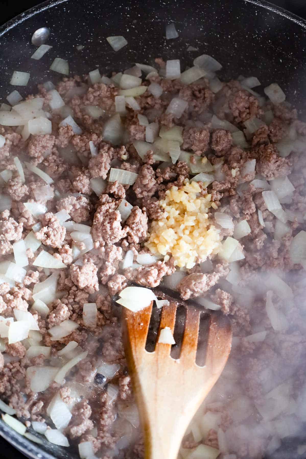 minced garlic added to skillet with cooked ground beef and diced onions