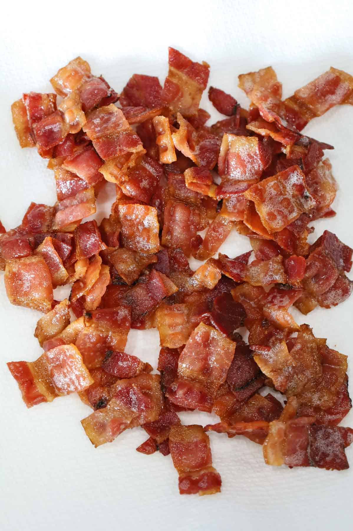 cooked bacon pieces on a paper towel lined plate