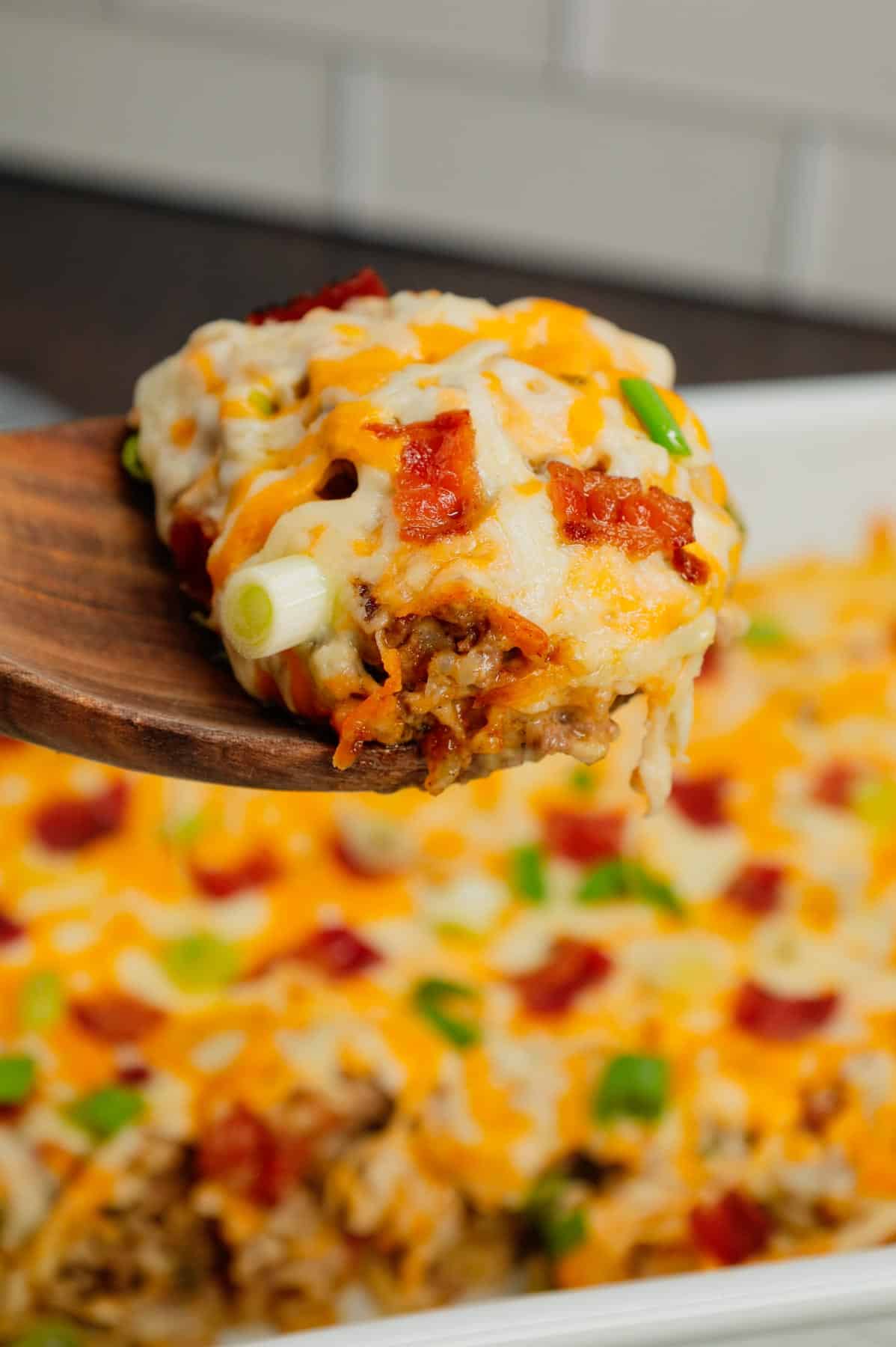 Cheesy Ranch Ground Beef and Rice Casserole is a hearty dinner recipe loaded with ground beef, instant rice, bacon, cheddar soup, milk, ranch dressing mix, chopped green onions and shredded cheese.