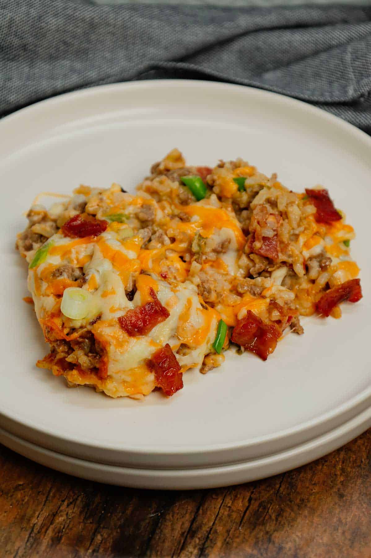 Cheesy Ranch Ground Beef and Rice Casserole is a hearty dinner recipe loaded with ground beef, instant rice, bacon, cheddar soup, milk, ranch dressing mix, chopped green onions and shredded cheese.